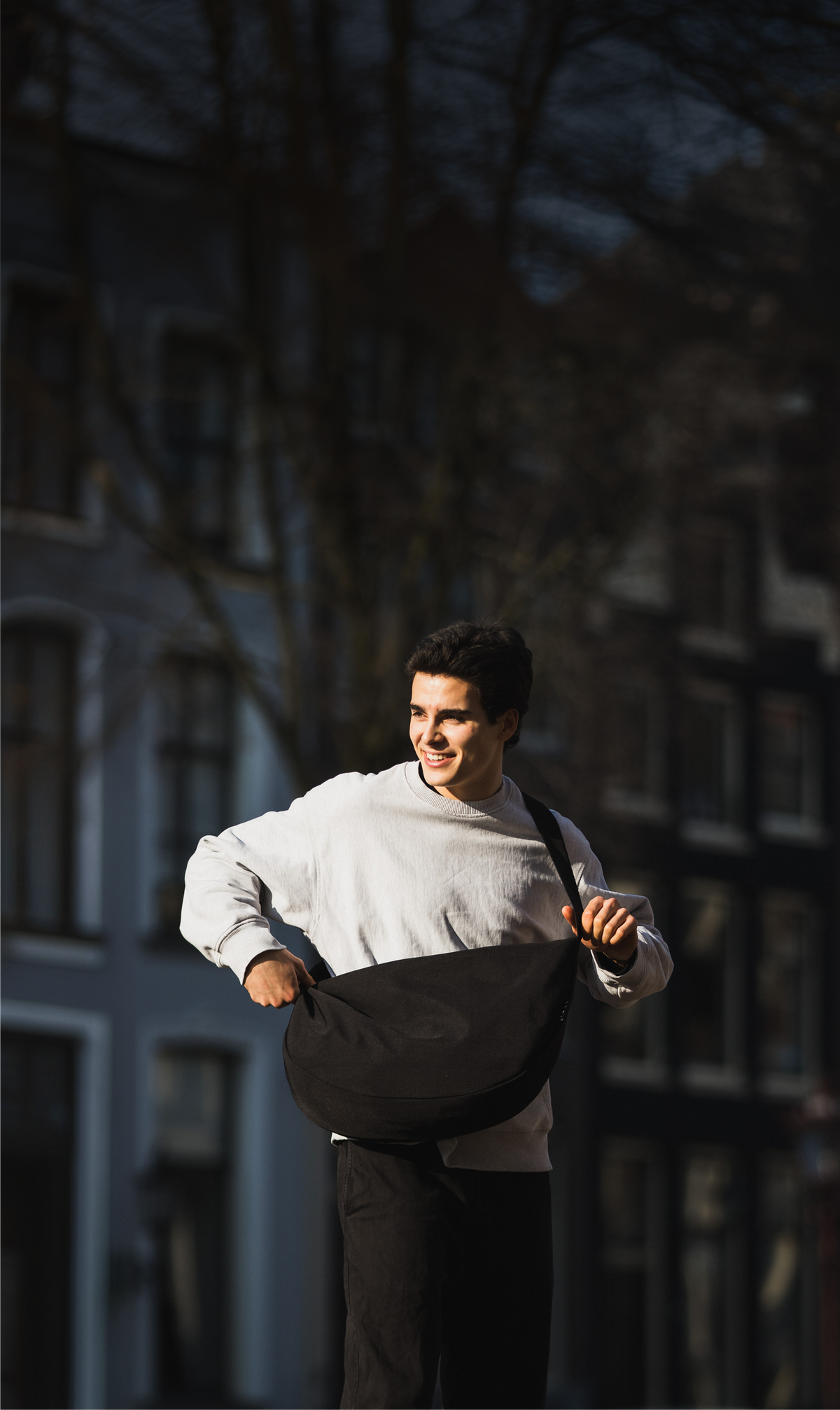 Commuter carrying a black TØTE bag through Amsterdam